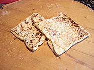 Finished pieces of gözleme resting flat on a table prior to being served.