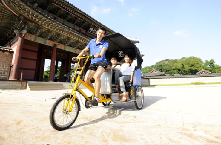 Tourists ride the Artee pedicab as they tour around Changdeok Palace, Jongno-gu, central Seoul. The pedicab business won the grand prize at the 2013 competition for 'creative tourism business model' run bythe Korea Tourism Organization. / Courtesy of Artee 