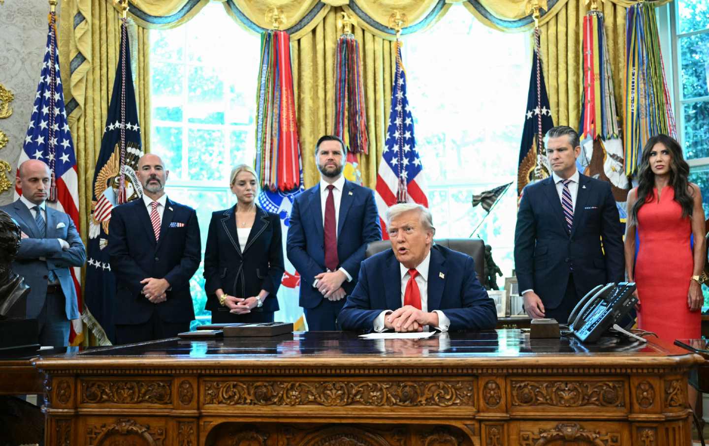 President Donald Trump speaks to the press before signing an executive order that aims to end cashless bail, in the Oval Office of the White House in Washington, DC, on August 25, 2025. Also pictured, from left to right, Deputy Chief of Staff Stephen Miller, Administrator Drug Enforcement Administration Terry Cole, US Attorney General Pam Bondi, Vice President JD Vance, Defense Secretary Pete Hegseth, and Secretary of Homeland Security Kristi Noem.