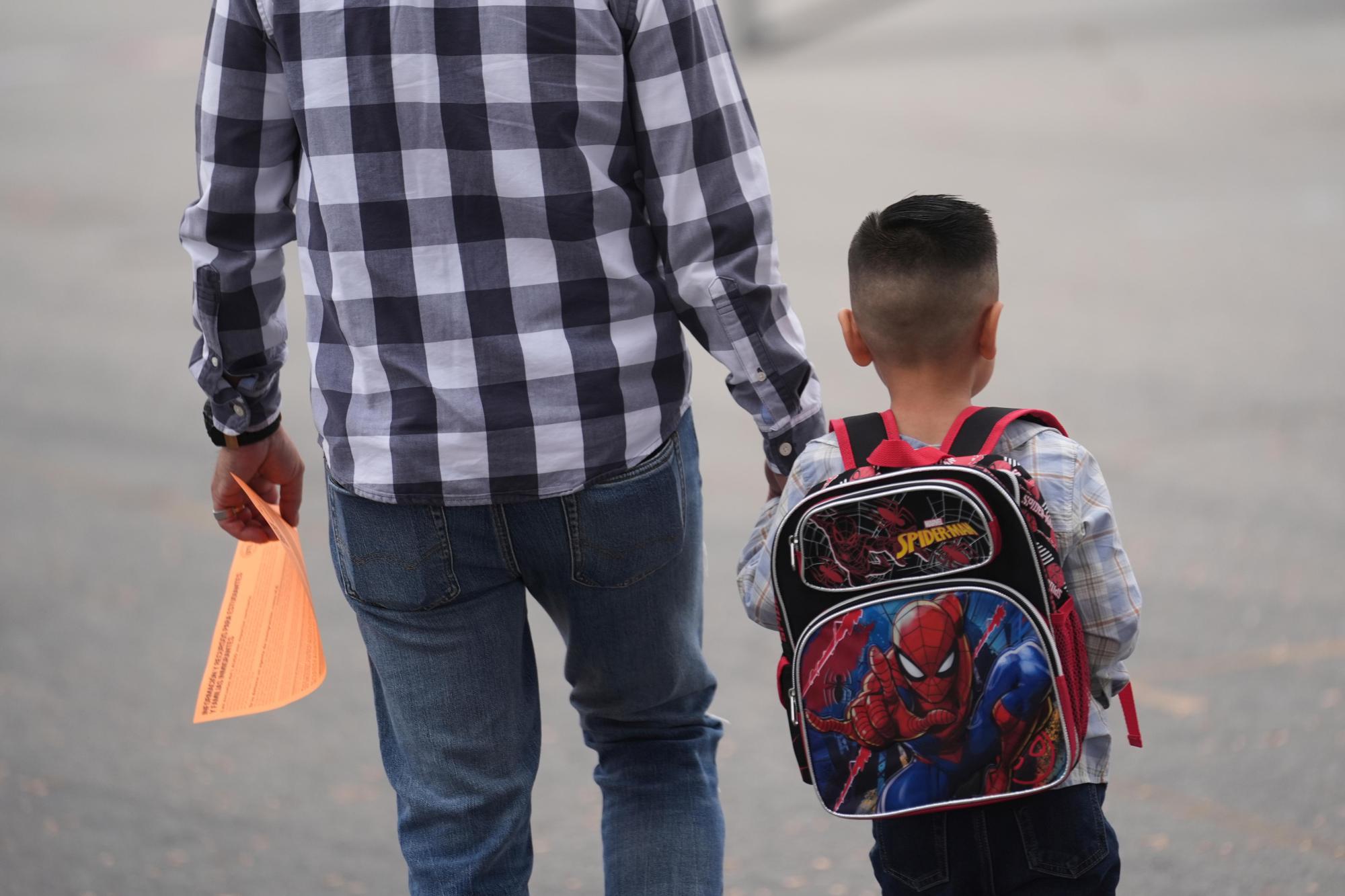A parent and student arrive on the first day of school Thursday, Aug. 14, 2025, in Los Angeles. (AP Photo/Marcio Jose Sanchez)
